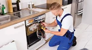 Technician testing exposed components on an open dishwasher